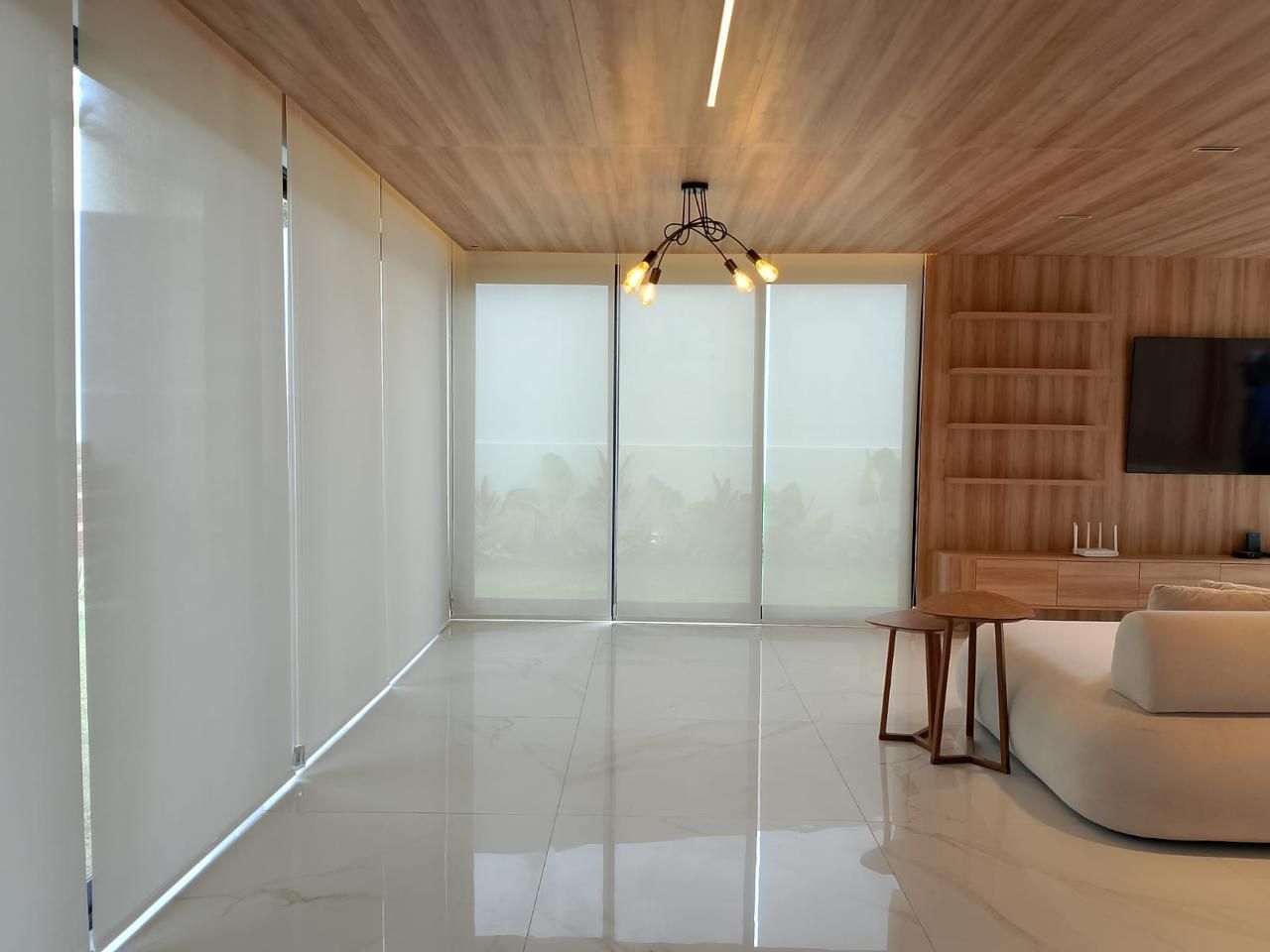 Sala ampla com persianas rolô